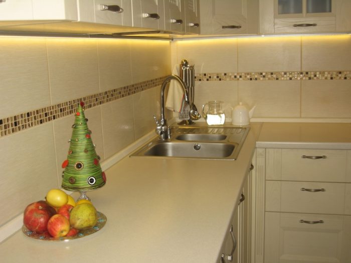2 rows of tile with a mosaic in the middle of the backsplash