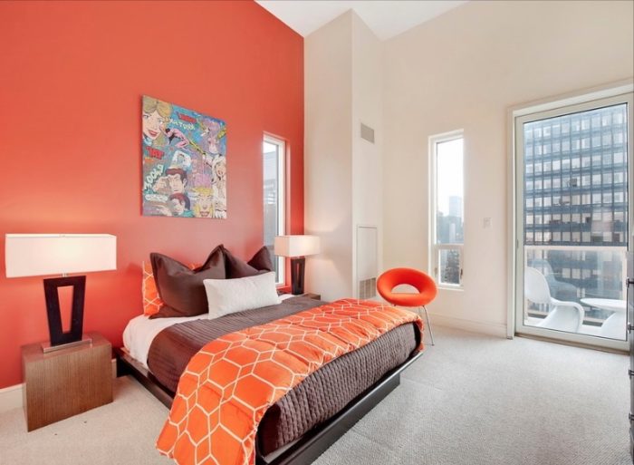 a bright red accent wall in the bedroom