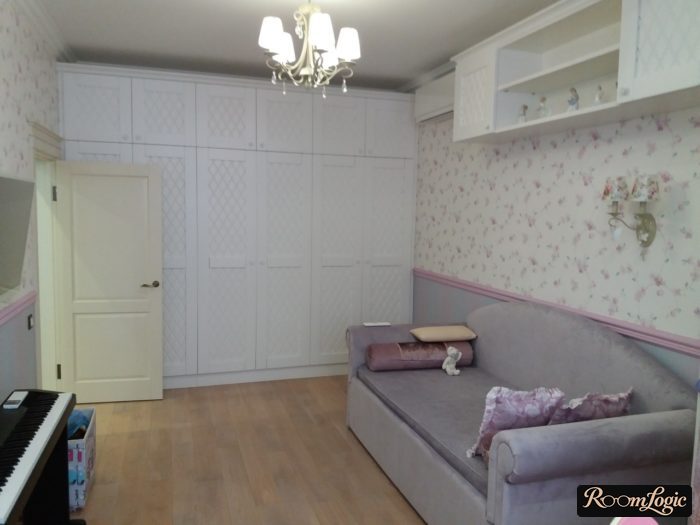a ceiling-to-floor closet next to the door in a teenage girl's room