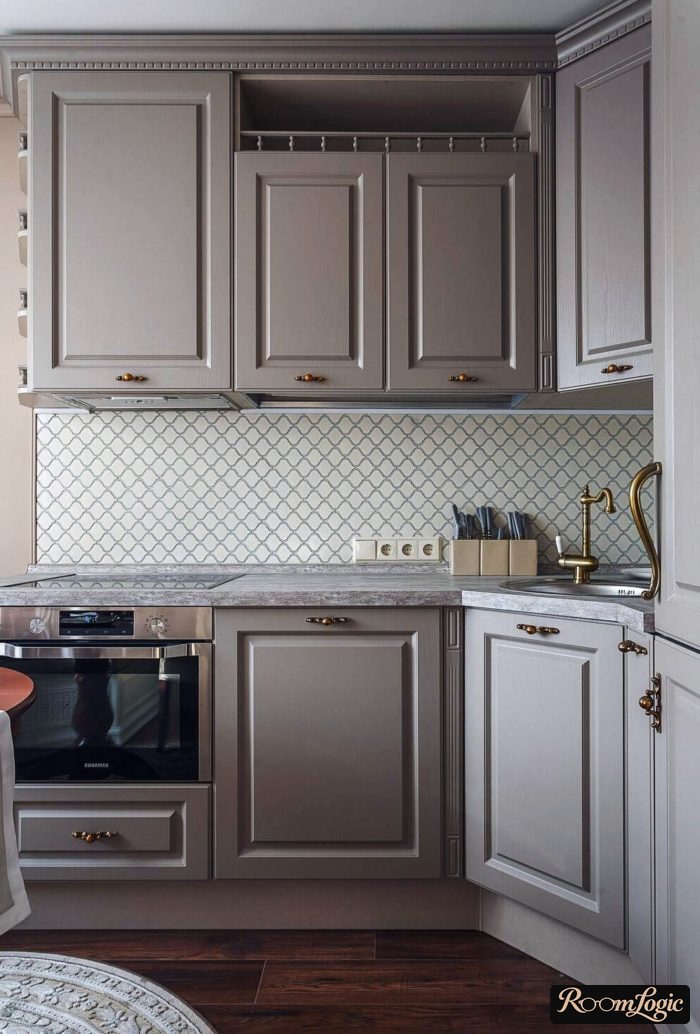 A gray-blue kitchen in a neoclassical style with a chandelier