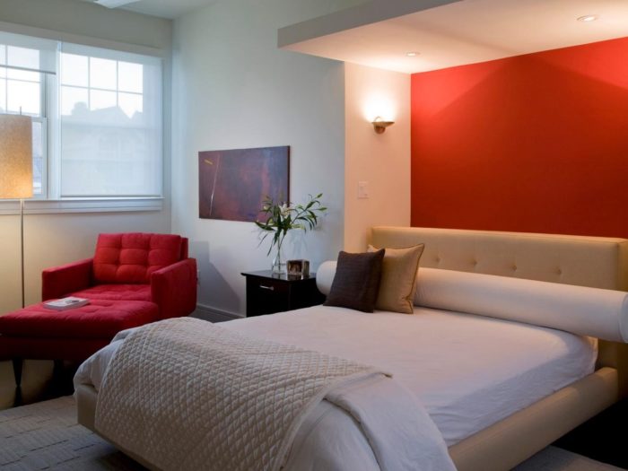 a red accent wall in the bedroom