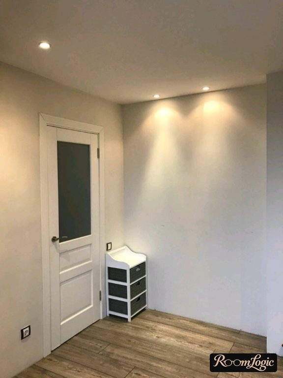 a small shoe rack in the corner of the hallway