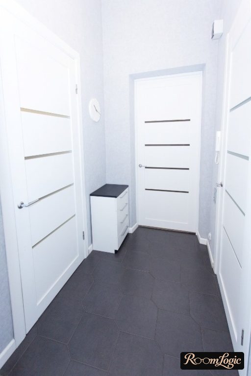 a small white cabinet in the corner of the hallway
