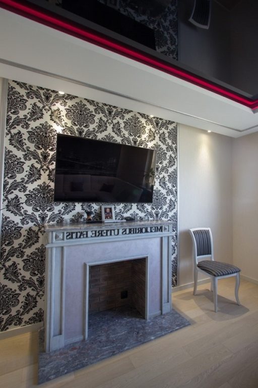 accent wall with patterned wallpaper and television