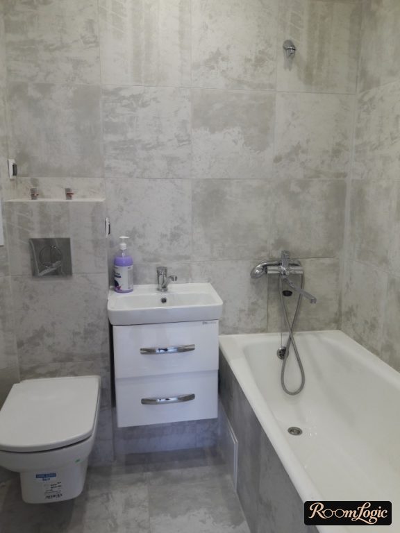 all bathroom walls in the tiny apartment are tiled with one type of tile