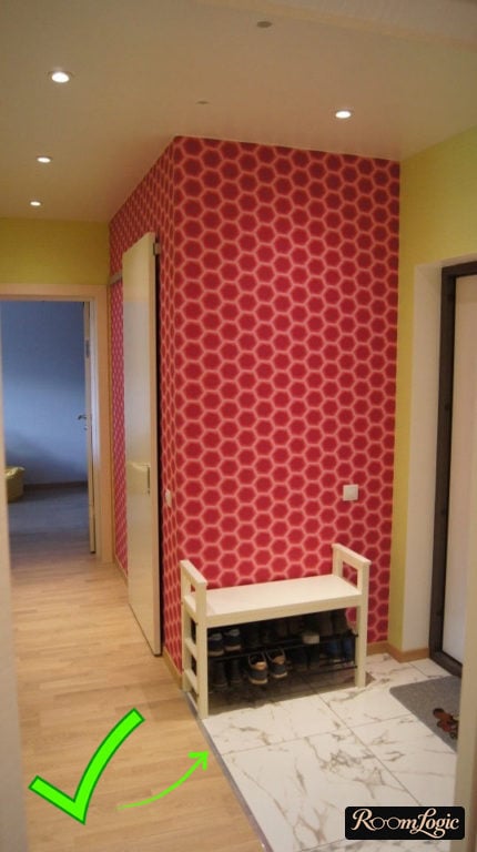 Aluminum transition strip at the joint between tile and laminate in the hallway