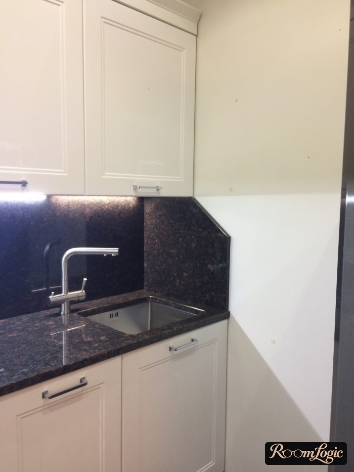 backsplash in the kitchen near the sink continuing onto the adjacent wall