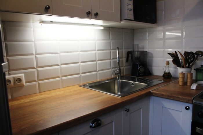 backsplash lighting with white subway tile in kitchen