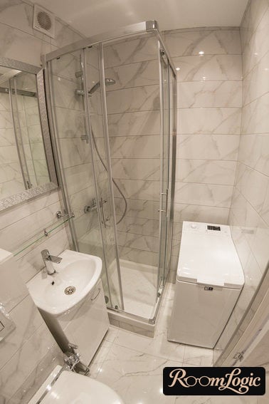 bathroom in a tiny apartment with a shower, washer, and toilet