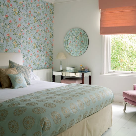 Bedroom interior with turquoise wallpaper and flowers