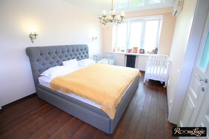 Bedroom with two children's cribs by the window