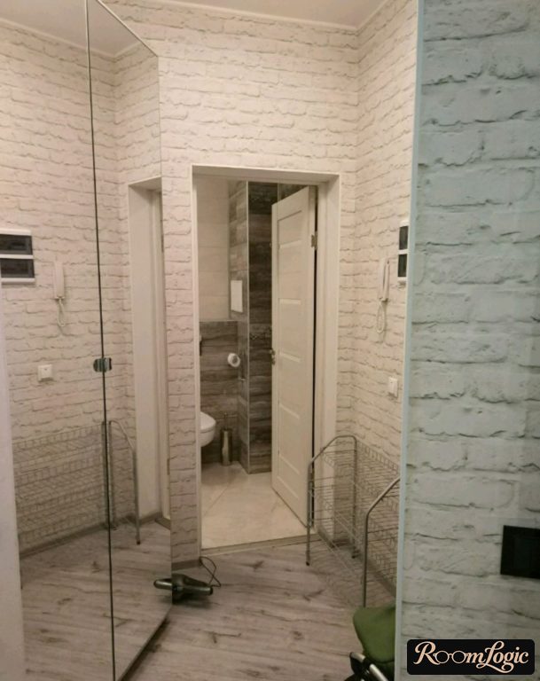 brick-imitation wallpapers and mirrored closet in a small entryway