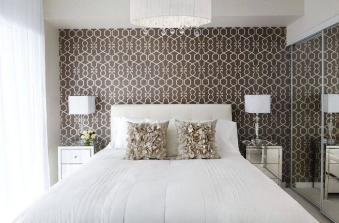 brown wallpaper with white pattern behind the bed