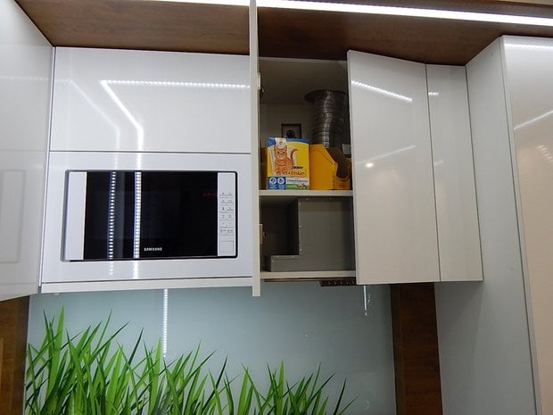Built-in white microwave in a tiny apartment