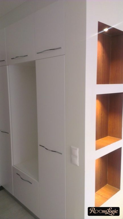 Built-in white wardrobe with a seating area in the small entryway