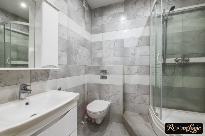 combination of gray and beige tile in the bathroom with a shower enclosure