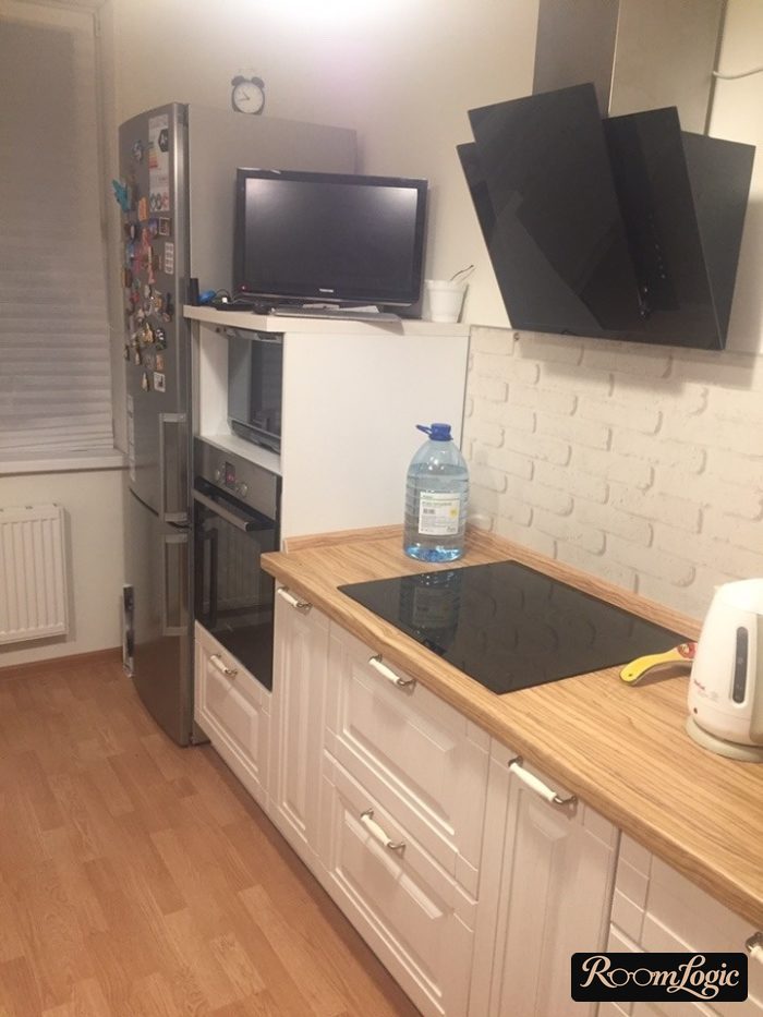 Concept kitchen with white cabinet fronts featuring routed detailing and a wooden countertop