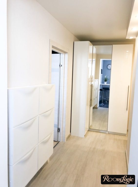 corner closet with mirrored doors and narrow bench in small hallway