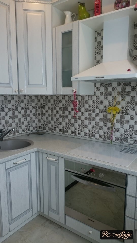 Corner kitchen cabinets extending to the ceiling in Provence style