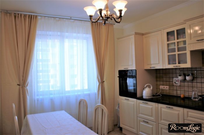 Cream curtains in a neoclassical style kitchen interior