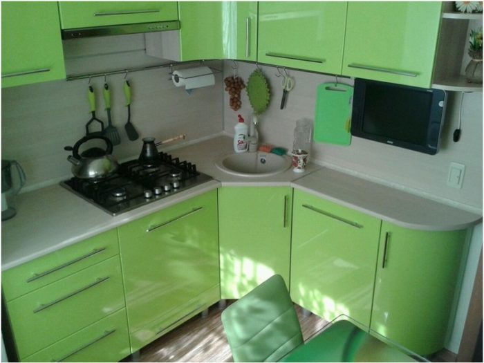 design of a green corner kitchen in a tiny apartment