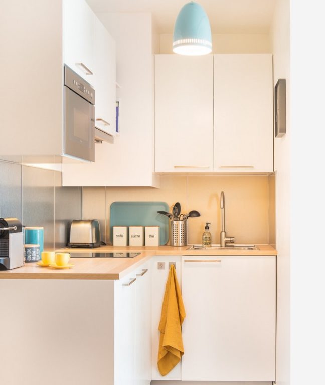 design of a kitchen in a tiny apartment with matte white cabinet fronts