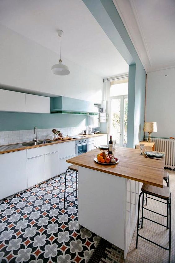 design of a kitchen in white and turquoise with patterns on the floor
