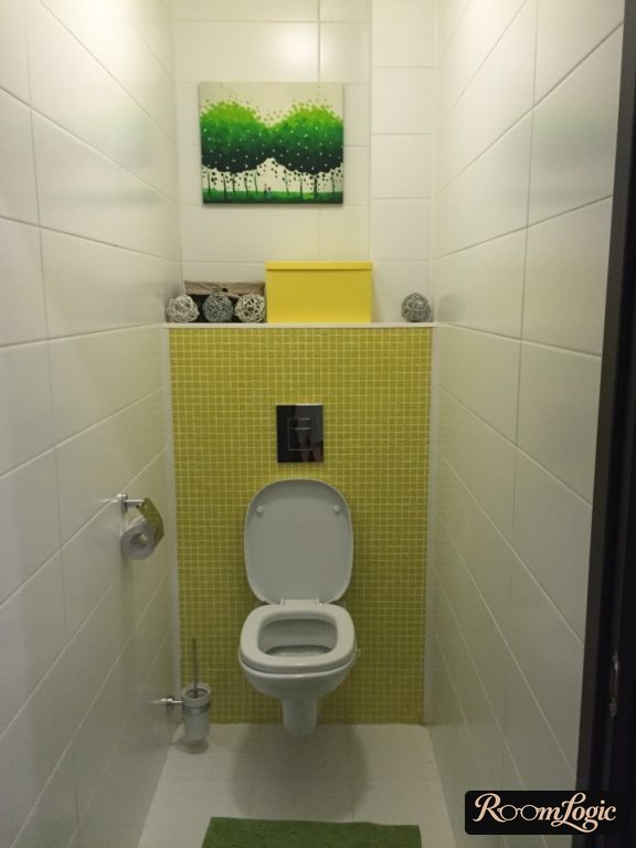 design of a toilet in an apartment with white tile and yellow mosaic
