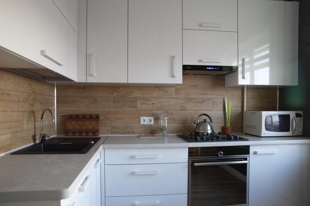 design of a white glossy kitchen in a tiny apartment