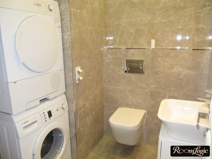 drying machine stands on washer in bathroom