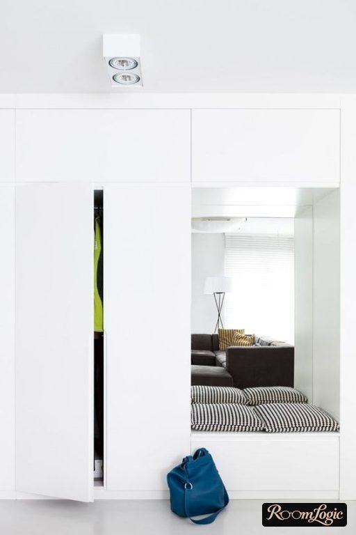 entryway closet with a seat and a mirror in the center