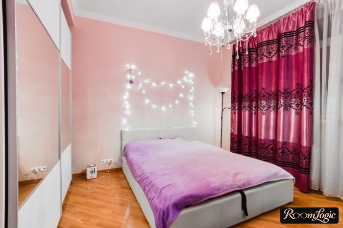girl's bedroom with string lights above the bed