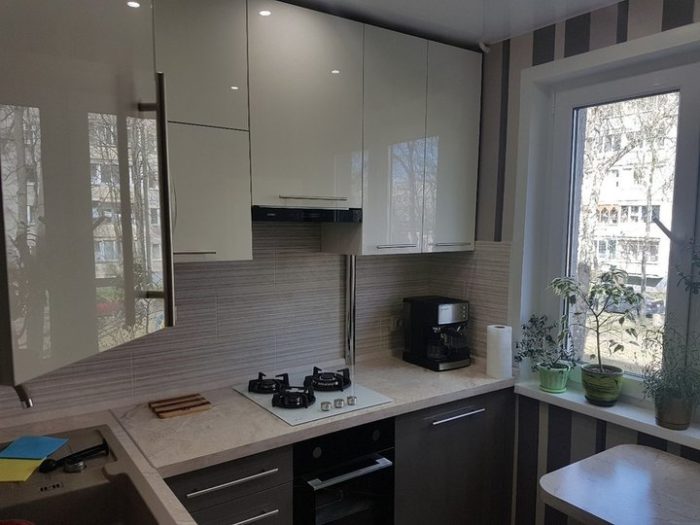 Glossy milk-white cabinet fronts in a small kitchen