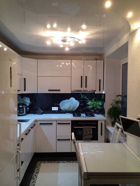 Glossy stretch ceiling in the kitchen of a tiny apartment