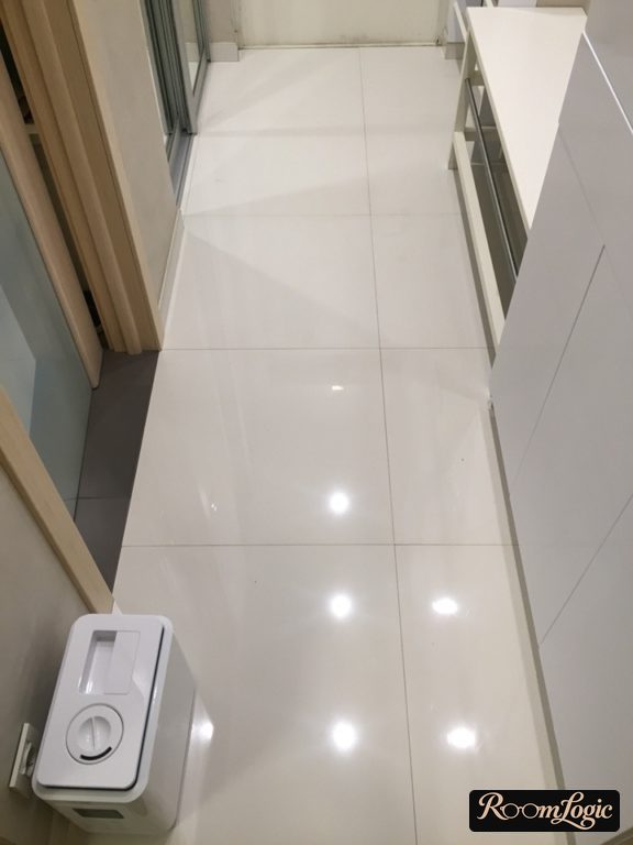 Glossy white square tile on the floor in the hallway