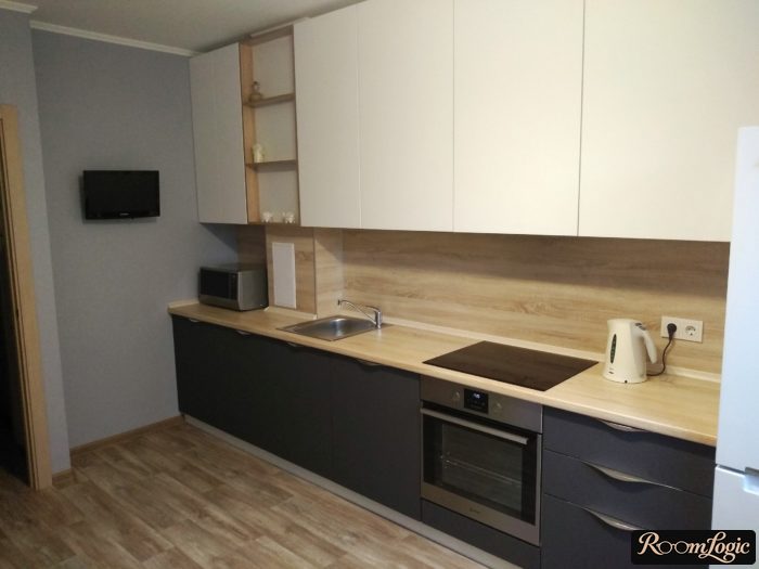 gray kitchen with wooden countertop and light upper cabinets