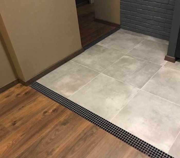 joint of floor tile with parquet in an entryway