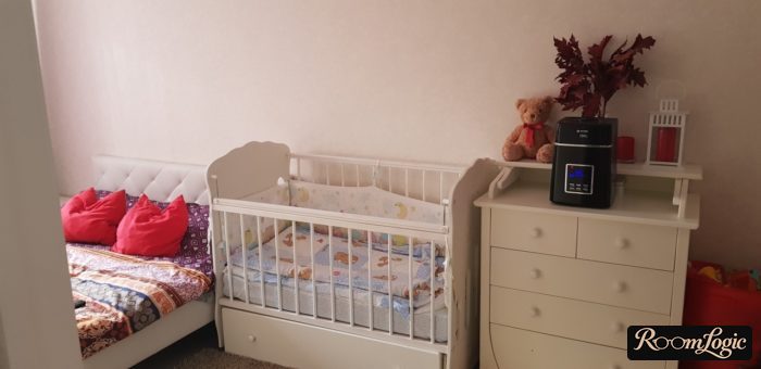 kids' crib perpendicular to bed in bedroom