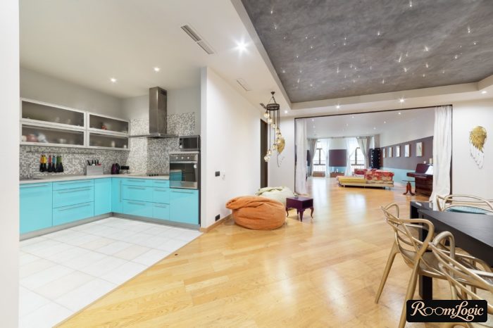 kitchen without a door with tile on the floor, adjacent room with laminate