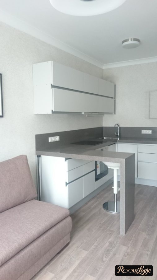 L-shaped kitchen with an open breakfast bar made of gray Corian