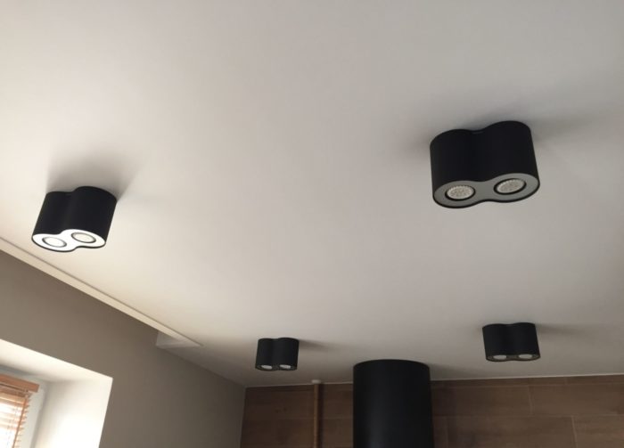 Matte white ceiling with black cylindrical light fixtures