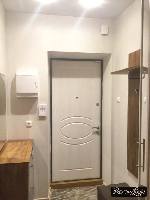 module entryway in hallway with cabinet, hooks, and pouf