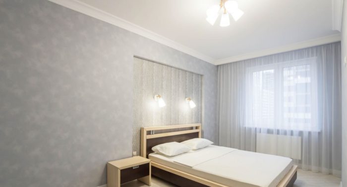 niche with wallpaper behind bed in bedroom