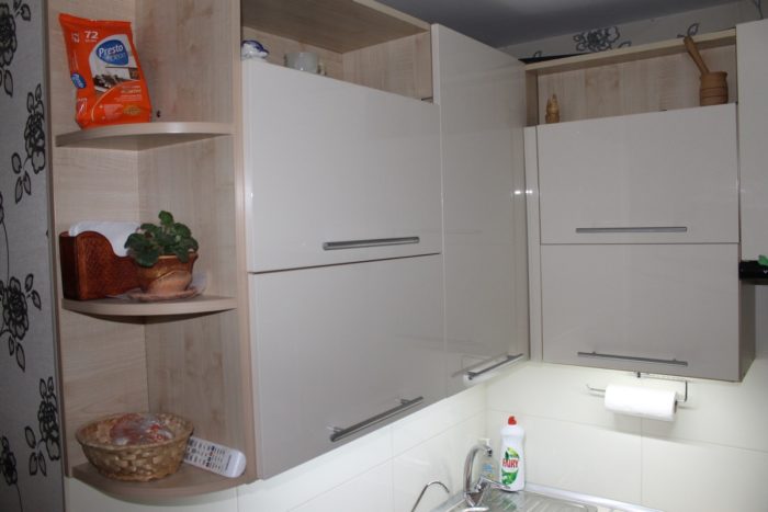 Open cabinets and shelves in the kitchen of a tiny apartment