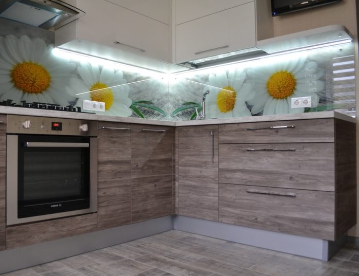 Photos of daisies behind the glass backsplash in the kitchen