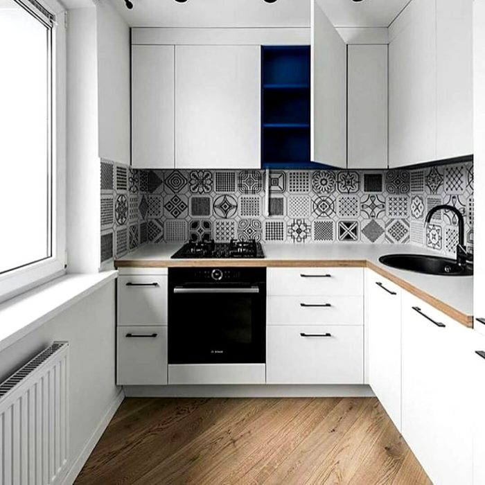 scandinavian-style kitchen with black-and-white tiled floor with a pattern