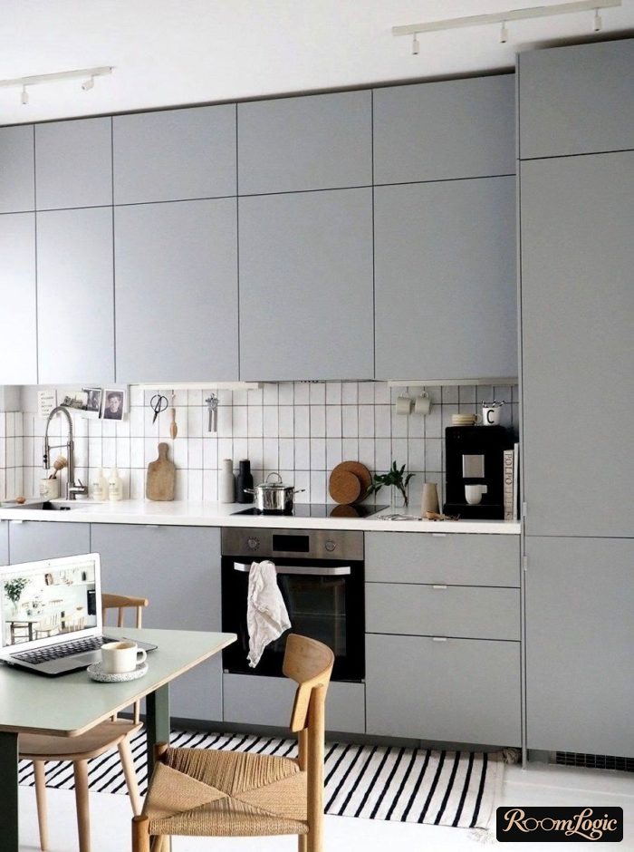 scandinavian styled kitchen with light gray matte cabinet fronts reaching to the ceiling