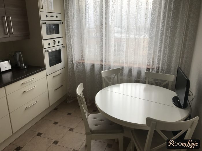 sheer curtain with a pattern in a small white kitchen