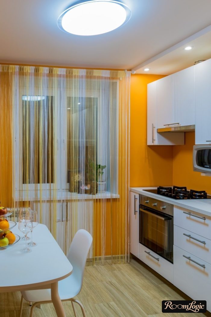 Sheer curtains in the form of threads in a kitchen with a balcony door