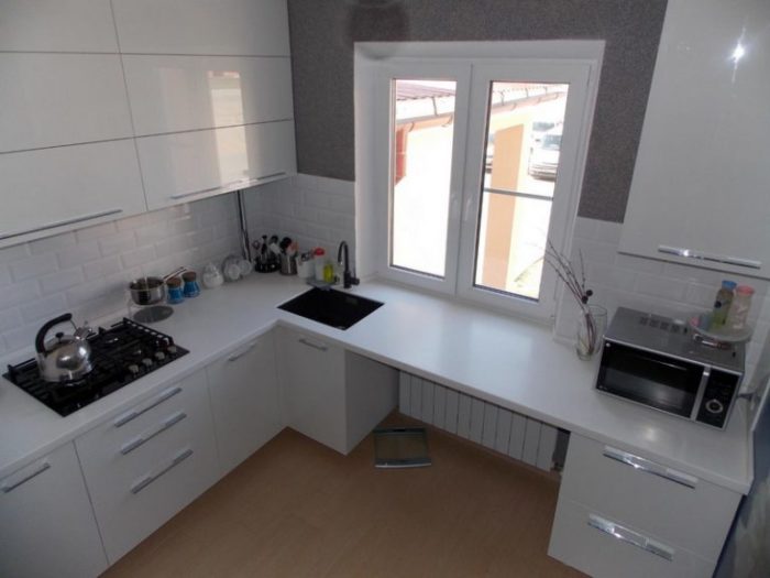 sink in countertop in place of window sill in tiny apartment